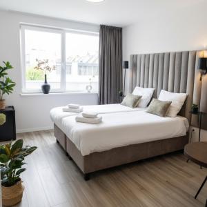 a bedroom with a large bed with a large window at Chic Suite W Bathroom & Kitchen in Geertruidenberg