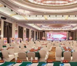a large banquet hall with white chairs and a projection screen at Country Garden Phoenix Hotel Jurong in Huangmeiqiao +287 photos