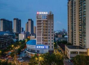 a tall building with a sign on it in a city at Echarm Hotel Nanchang Hongcheng Wangfujing in Taohua