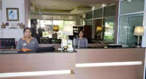 Dos mujeres sentadas en un mostrador en un restaurante en Nonsi Hotel Phitsanulok, en Ban Wat Tha Maprang