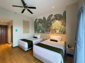 Solea Seaview Resort في ماكتان: غرفة نوم بها سريرين ومروحة سقف