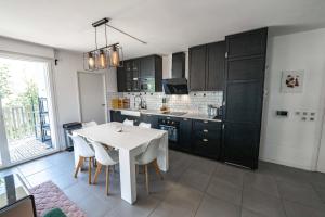 a kitchen with a white table and white chairs at Bright Apartment Near the lake in Bordeaux