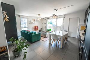 a living room with a green couch and a table at Bright Apartment Near the lake in Bordeaux