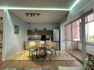 a kitchen and dining room with a table and chairs at Уютная и комфортная 3х комнатная в новом центре in Oral