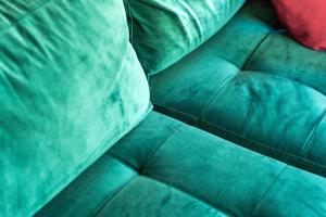 a close up of a green couch with a pillow at Bright Apartment Near the lake in Bordeaux