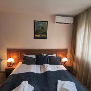 ein Schlafzimmer mit einem großen Bett mit zwei Lampen in der Unterkunft Ski view suite Emerald Bansko in Bansko