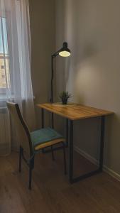 un bureau en bois avec une chaise et une lampe dans l'établissement Уютная и комфортная 3х комнатная в новом центре, à Uralsk