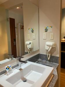 Solea Seaview Resort في ماكتان: حمام مع حوض ومرآة كبيرة