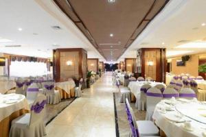 DianbailiaoにあるManhatton Hotel Beihaiの白いテーブルと紫色の椅子が備わる宴会場