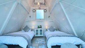two beds in a room with a window at Dream Dome Glamping Studio Ichihara in Ichihara