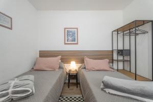 1 dormitorio con 2 camas y almohadas rosas en Gar House, en Caleta de Interián