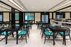 a dining room with black tables and chairs at Xana Hotelle·Xiamen Railway Station in Xiamen