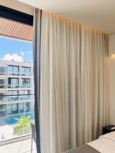 a bedroom with a bed and a large window at Porto Alto Resort in Porto De Galinhas +80 photos