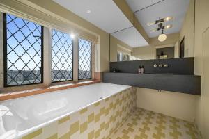 a bathroom with a large tub and two windows at Finest Retreats - ARC Thorpeness in Thorpeness