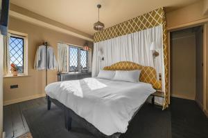 a bedroom with a large bed with a yellow headboard at Finest Retreats - ARC Thorpeness in Thorpeness