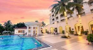 a hotel with a swimming pool in front of a building at Sono Belle Haiphong in Trại Kênh