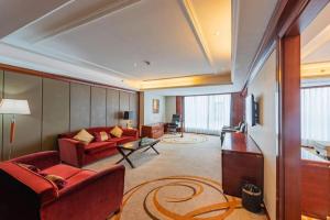 sala de estar con sofá rojo y TV en Dandong Xin An Dong Hotel, en Dandong