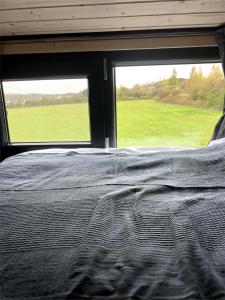 una cama en una habitación con una ventana grande en Ridge Hill X by Tiny Away, en Wilmington