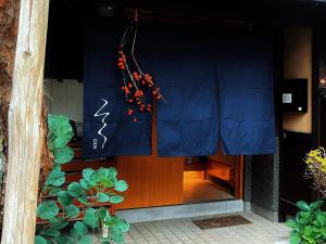 高山玄Gen的一栋建筑物的正门,门上挂着蓝色窗帘。