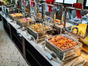 a buffet line with many trays of food on display at Hanoi Discovery Old Quarter Hotel in Hanoi +45 photos