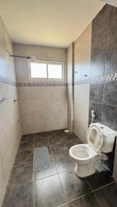a bathroom with a toilet and a window at Hillsview Apartment in Voi