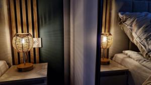 a bedroom with two lamps on a table next to a bed at Domek z widokiem Wilczy Jar in Jarnołtówek