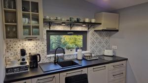 a kitchen with a sink and a window at Domek z widokiem Wilczy Jar in Jarnołtówek