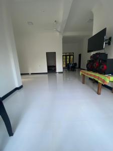 ein Wohnzimmer mit einem Tisch und einem Flachbildfernseher in der Unterkunft Diyaluma Villa Resort in Koslanda + 34 Fotos