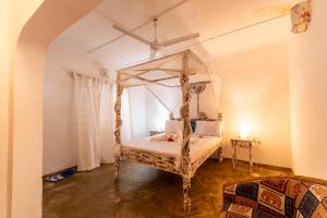 a bedroom with a canopy bed in a room at Paradise Lagoon B&B in Watamu