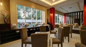 a restaurant with tables and chairs and a large window at Hotel Betha Subang in Subang +39 photos