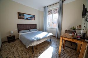 a bedroom with a bed and a table and a window at Affittacamere Al Passatore in Ravenna