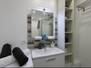 une salle de bain blanche avec un lavabo et un miroir dans l'établissement Fronte mare-Free parking-ideale inverno-wi fi, à Menton