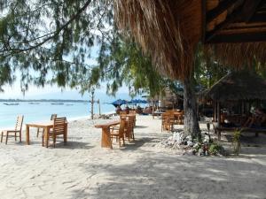 a group of tables and chairs on the beach at Melati Cottage in Gili Trawangan