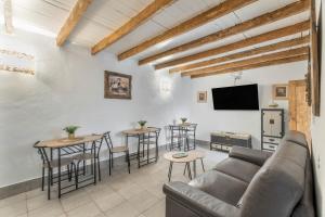 sala de estar con sofá, mesas y TV en Gar House, en Caleta de Interián