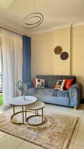 a living room with a blue couch and a table at Hillsview Apartment in Voi