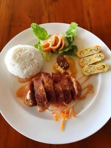 a plate of food with rice and meat and vegetables at Dream Hotel in Sabang