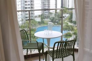 ジョホールバルにあるDanga Bay Point - 3BR Kid Scandi Loungeのプールを望むバルコニー(テーブル、椅子付)