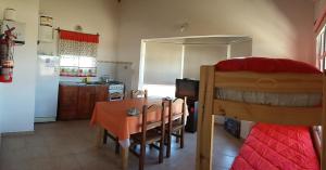 a kitchen and dining room with a table and a bed at Brisa de los Molles in Los Molles