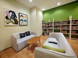 ジョホールバルにあるDanga Bay Point - 3BR Kid Scandi Loungeのリビングルーム(ソファ、テーブル、本棚付)