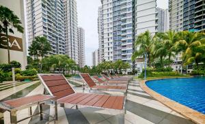 ジョホールバルにあるDanga Bay Point - 3BR Kid Scandi Loungeのスイミングプールの横に座る椅子