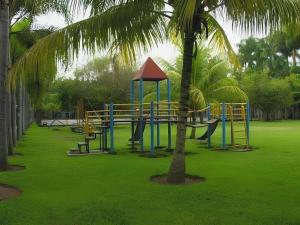 a playground in a park with a palm tree at Augusta Pelabuhan Ratu Hotel in Citepus