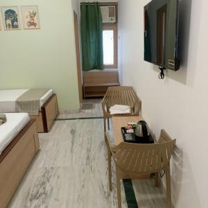 Una habitación con una cama y un televisor en la pared. en Shri Thakur Ji Niketan, en Vrindāvan 8 fotos más