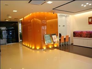 a lobby with an orange wall with a sign in it at Jinjiang Inn Qingdao Development Zone Jinggangshan Rd. in Huangdao