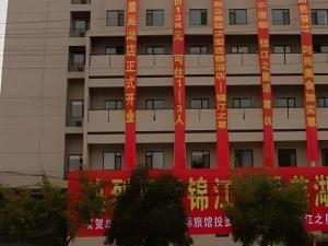 an apartment building with red and orange signs on it at Jinjiang Inn Wuhu High-Speed Railway Station West Square in Wuhu