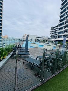 ダーバンにあるPearlviewのプール付きのデッキにテーブルと椅子が並ぶ