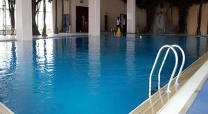 a large swimming pool with blue water in a building at Hohhot Inner Mongolia Hotel in Hohhot