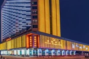 a tall building with lights on it at night at City Viva Hotel Macau in Macau
