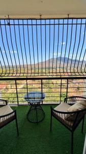 a balcony with two chairs and a table and a view at Hillsview Apartment in Voi