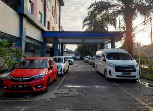 eine Gruppe von Autos, die an einer Tankstelle geparkt sind in der Unterkunft Hotel Marlin Pekalongan Managed by Dafam in Waru Lor