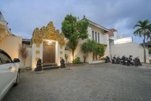 a car parked in front of a building with motorcycles at Natasya Kuta Beach Hotel in Kuta
